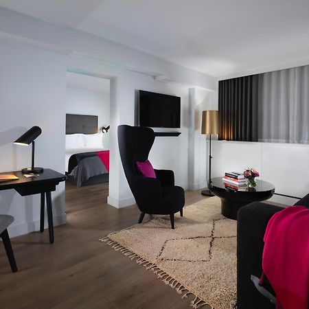 Sea Containers London Hotel Exterior photo The photo depicts a modern living space, likely part of a hotel room or suite. The room features:

- A comfortable seating area with two stylish armchairs in black, adorned with pink throw pillows.
- A small coffee table in the center, accompanied by