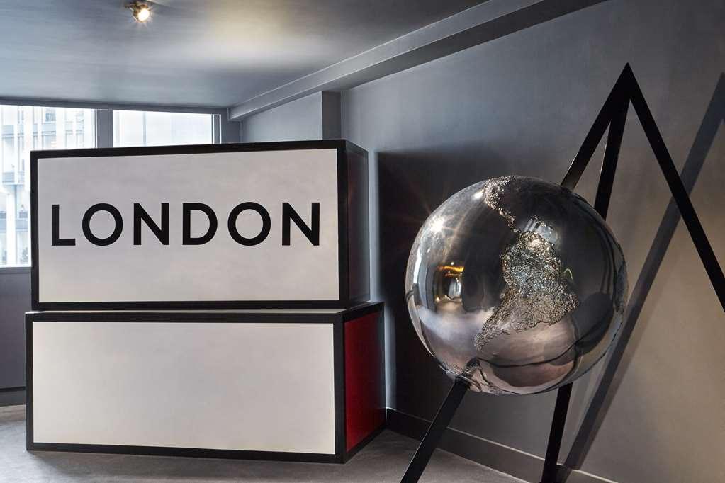 Sea Containers London Hotel Interior photo The photo depicts a modern interior space featuring a prominent sign that reads "LONDON" in bold, black letters. Behind the sign, there is a simple, geometric design with a red and black color scheme. To the right of the sign, there is a large, refle